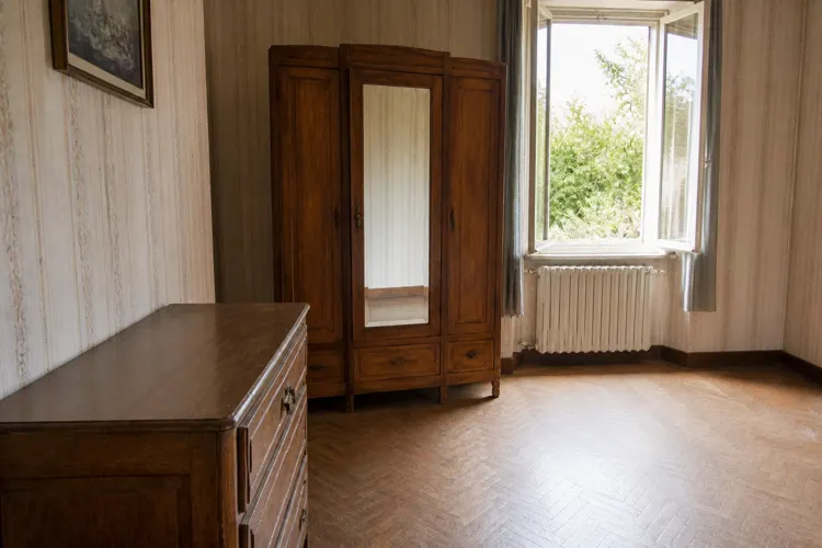 La même chambre vidée et nettoyée : fenêtre ouverte, sol dégagé et pièce claire.